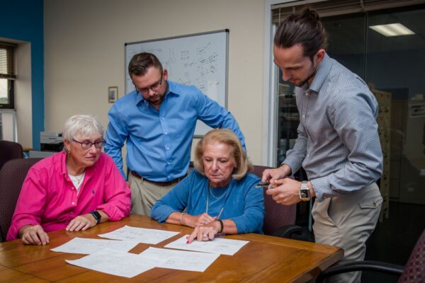 Extreme-Molding-Approach-team-members-looking-at-injection-molding-plans-600x400