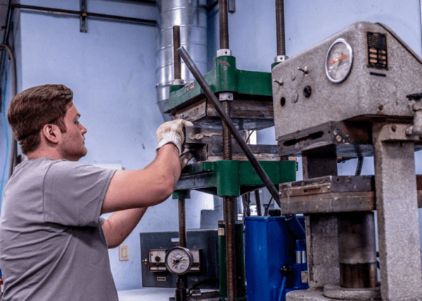 extreme-molding-team-member-using-HCR-molding-machine-600x429